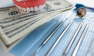 money in dentures with dental tools