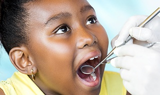 Child receiving dental checkup and teeth cleaning for kids
