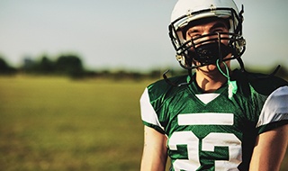 Boy with mouthguard playing football in Marlton