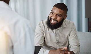 a smiling man sitting in a chair