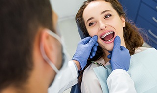 Dentist talking to smiling patient in treatment room