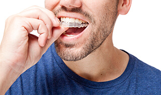 Closeup of man placing an Invisalign tray