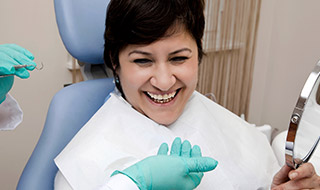 Woman smiling while receiving dental services in Marlton New Jersey