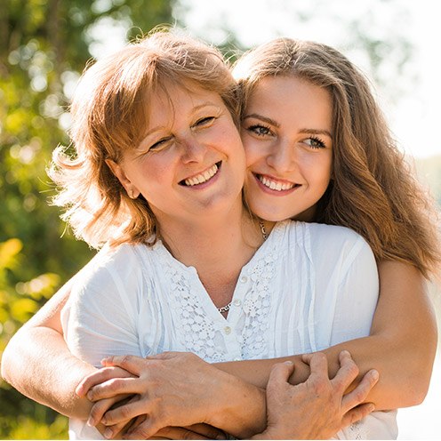 Daughter hugging mother from behind