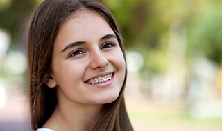 Young girl with braces smiling with low friction orthodontics