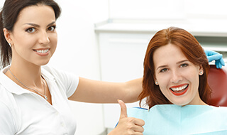 Dental patient giving a thumbs up.