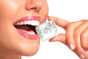 woman with ice between teeth