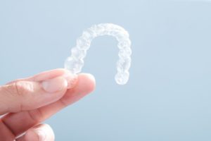 male hand holding Invisalign aligner