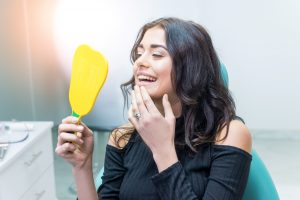 Woman with mirror looking at parts of mouth