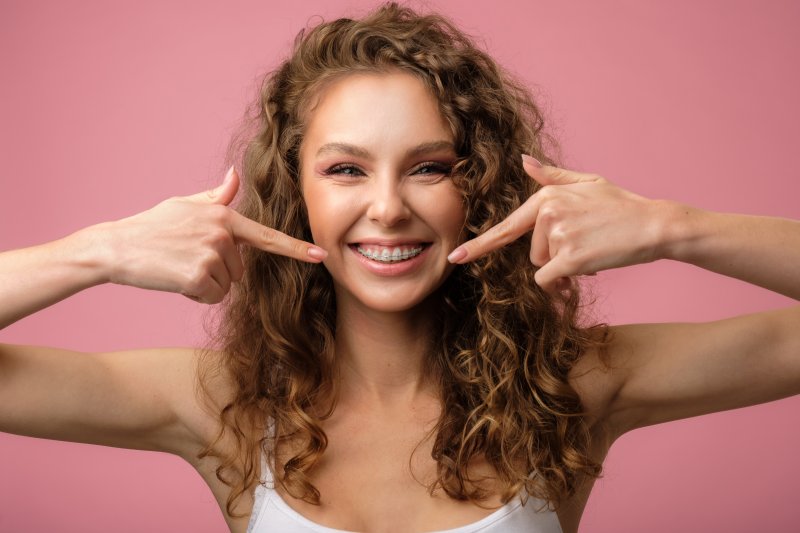 young girl pointing to her metal braces