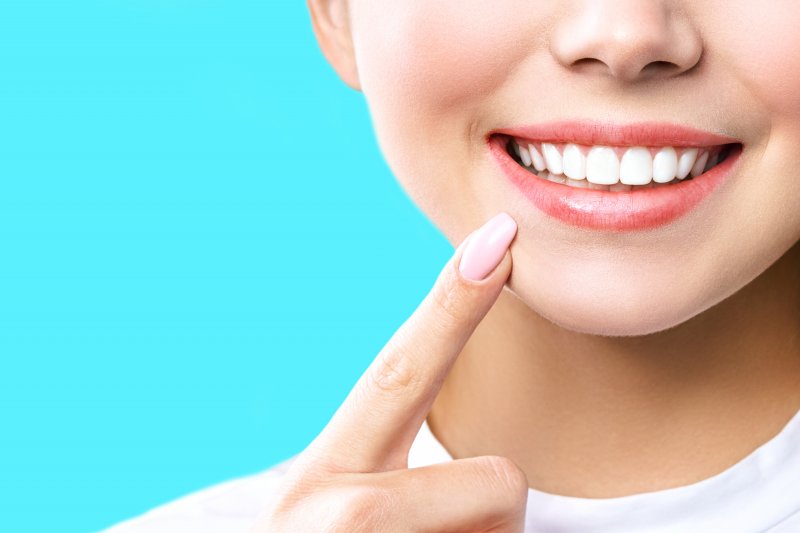 Woman pointing to the results of her teeth whitening