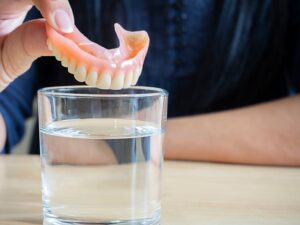 Person soaking their dentures for the night
